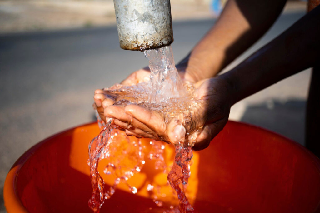 african woman pouring water recipient outdoors 23 2149021909
